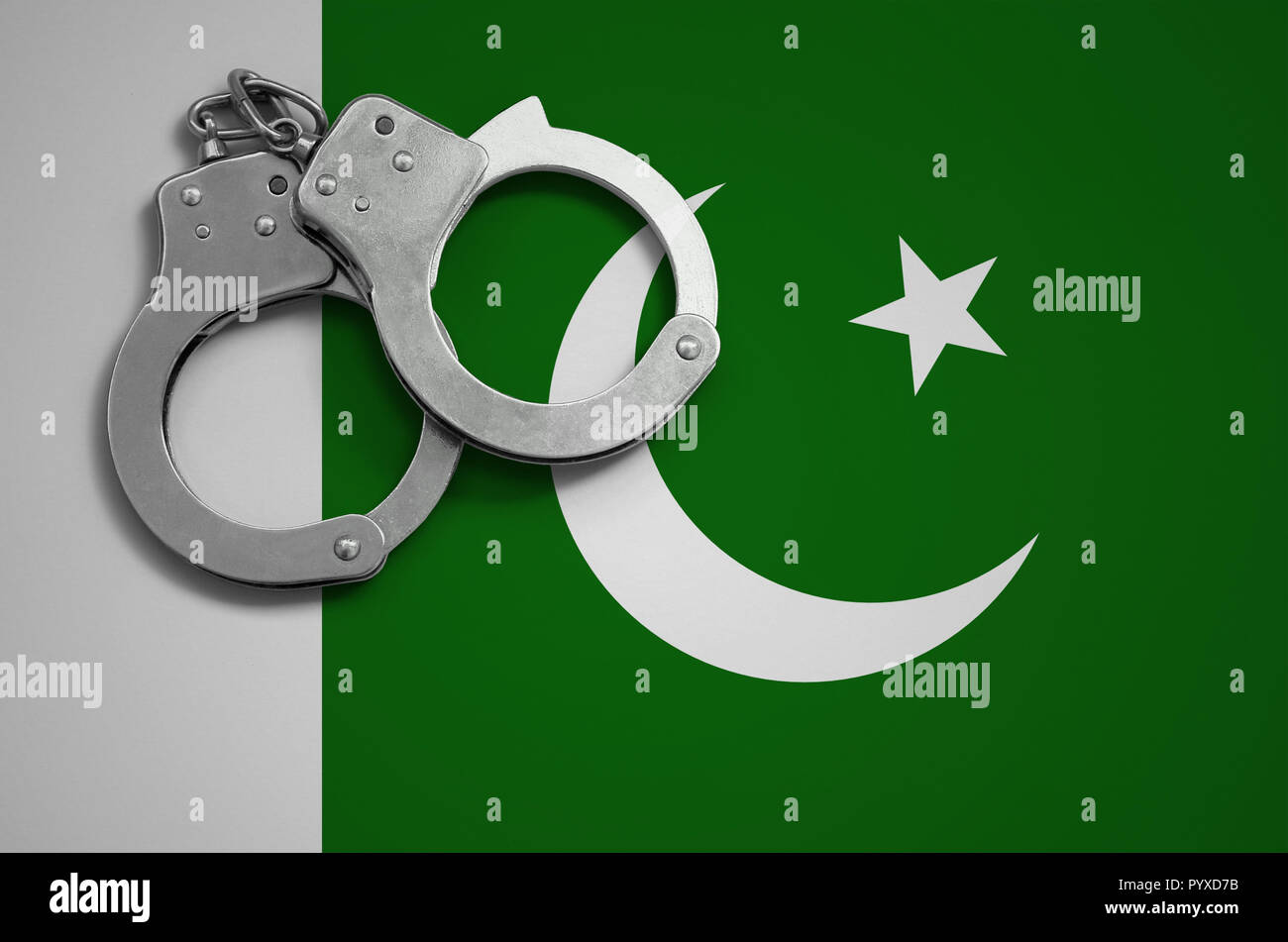 Pakistan flag and police handcuffs. The concept of crime and offenses
