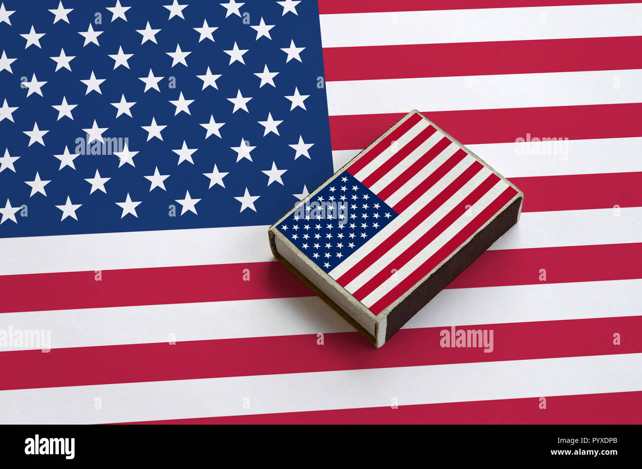 United States of America flag  is pictured on a matchbox that lies on a large flag. Stock Photo