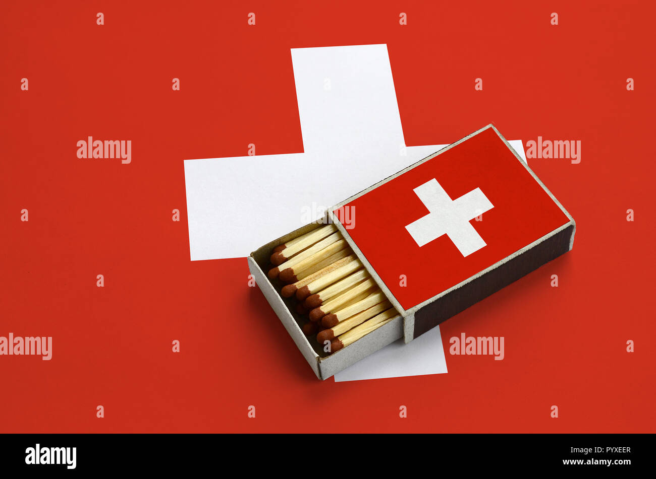 Switzerland flag is shown in an open matchbox, which is filled with matches  and lies on a large flag Stock Photo - Alamy