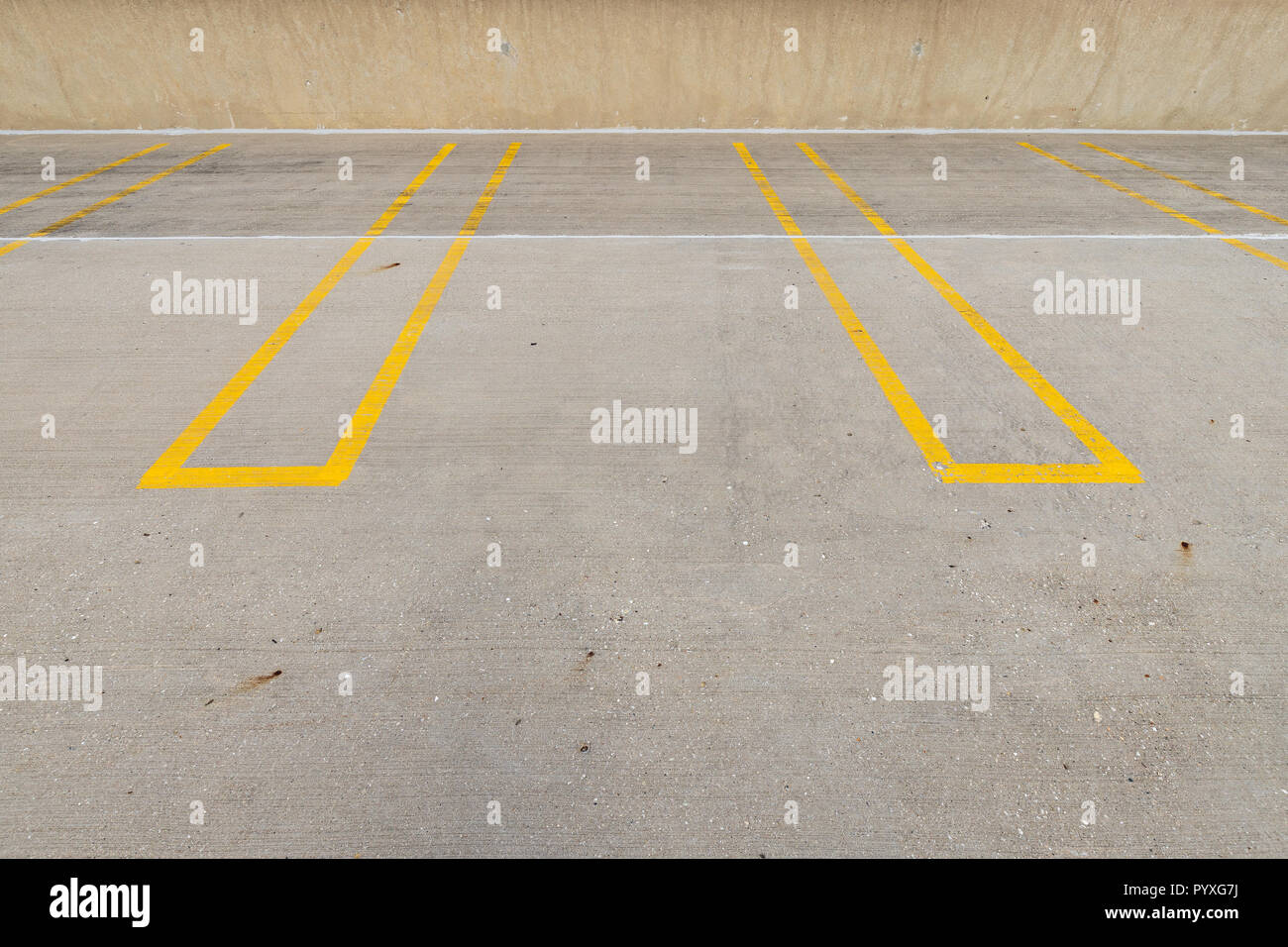 Empty parking spaces with yellow lines in a parking garage Stock Photo