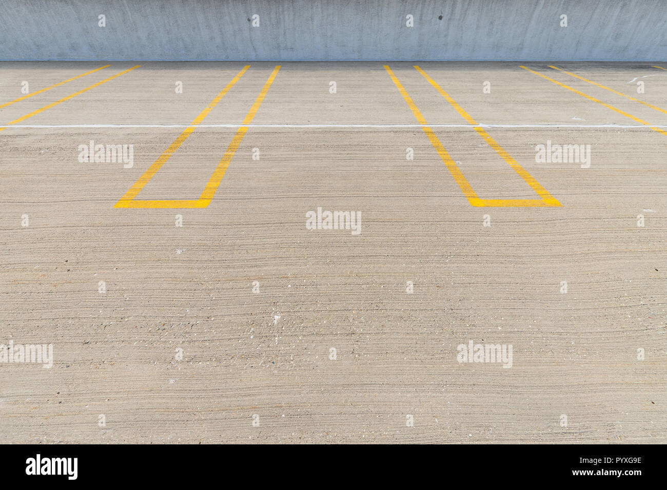 Empty Parking Spaces With Yellow Lines In A Parking Garage Stock