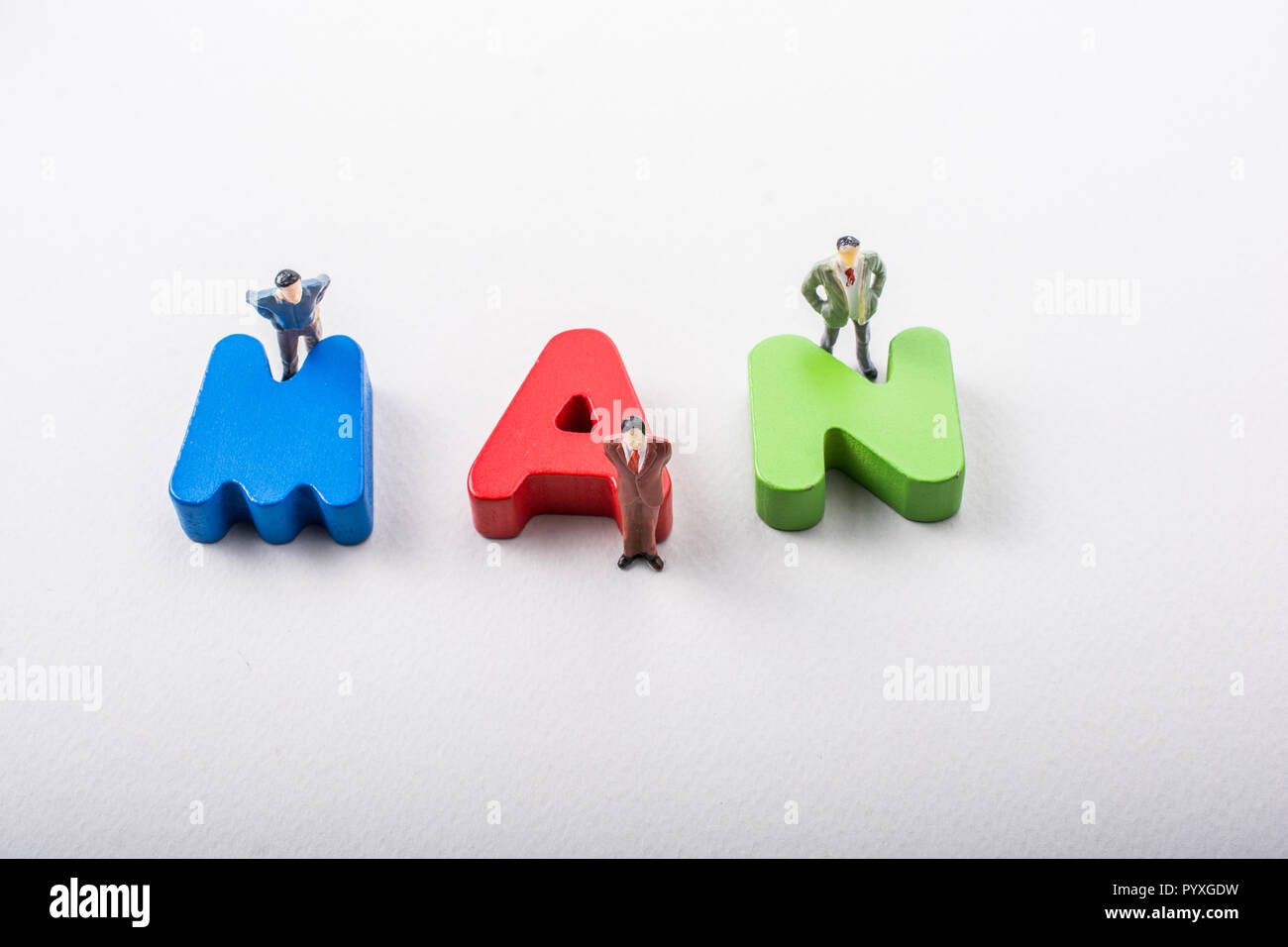 Tiny figurine of men beside colorful wooden letters say MAN Stock Photo ...