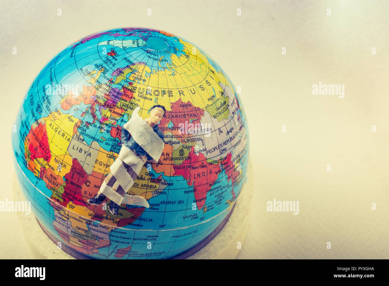 Tiny figurine of man model wrapped in bandages on earth Stock Photo