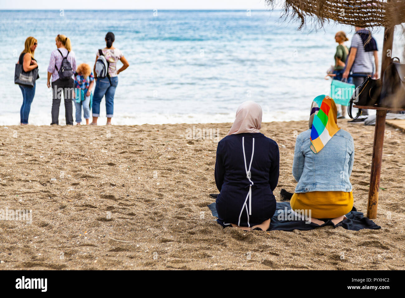 Moslem women praying on beach, Malaga, Andalusia, Spain Stock Photo