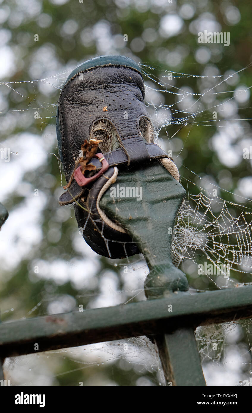 child's shoe impaled on metal railing spike Stock Photo