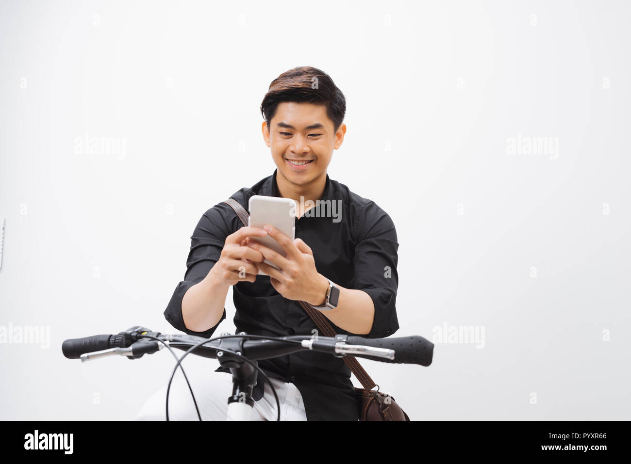 Shot of a businessman using his cellphone while going to work with his bicycle Stock Photo