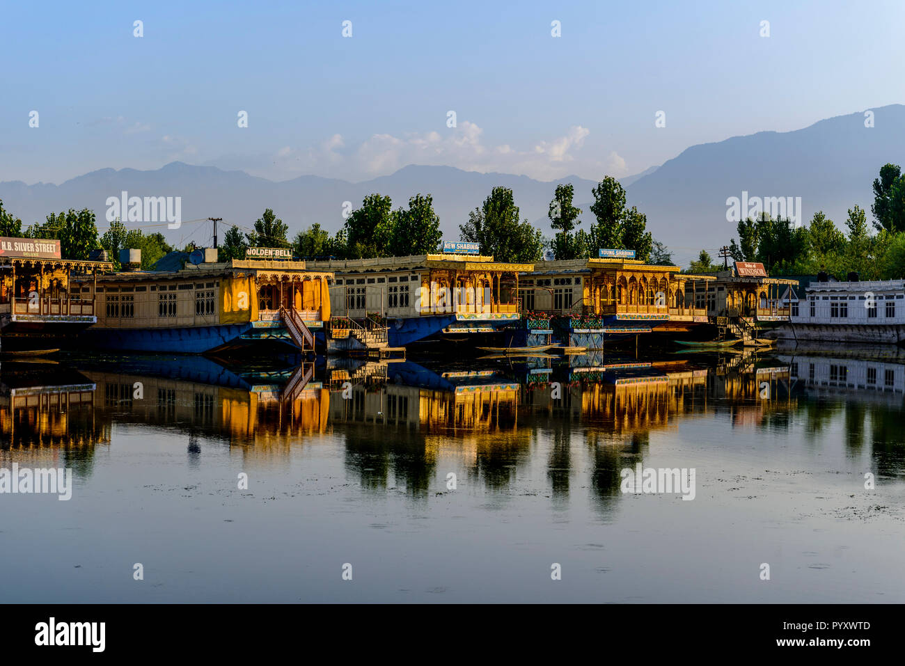 Houseboats for rent, anchored at Dal Lake and mirroring in the water, are the main attraction for Tourists visiting Kashmir Stock Photo