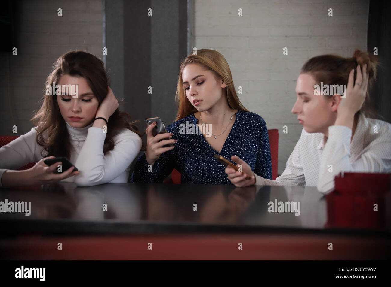 Young beatiful women communicated at comfortable cafeteria while waiting friend Stock Photo
