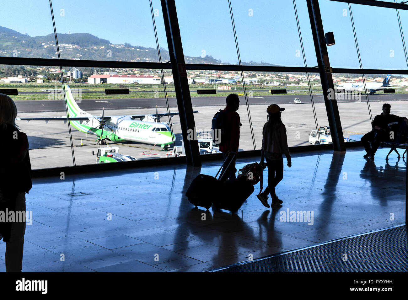 Spain; Canary Islands: Tenerife. Tenerife North Airport. Silhouette of passengers in the terminal and plane of the Spanish airline Binter Canarias, op Stock Photo