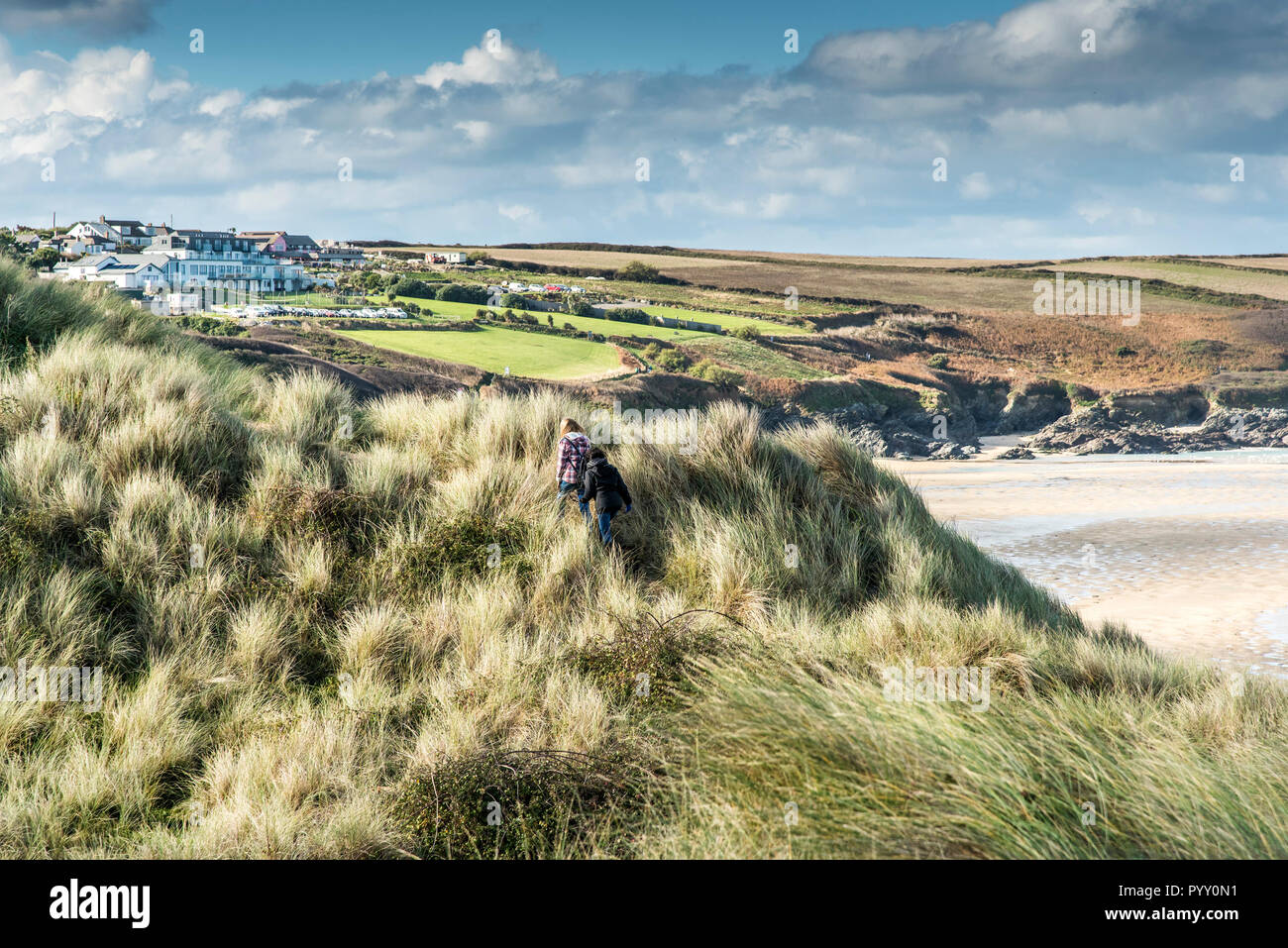 People walking through Marram Grass Ammophila on Crantock Sand dune system onj the coast of Newquay in Cornwall. Stock Photo