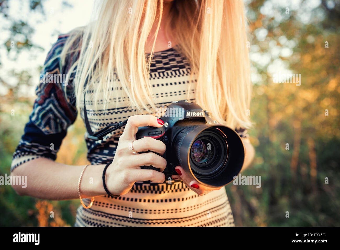 Moscow, Russia - October 4, 2014: Girl photographer holds Nikon D610 camera and Nikkor 50mm f/1.4G lens Stock Photo
