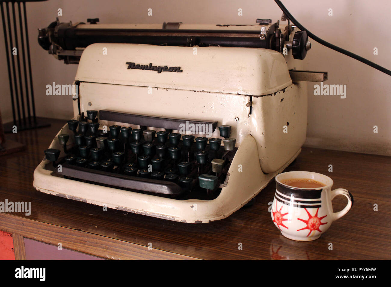 Translation: the vintage typewriter Remington or type machine and a cup ...