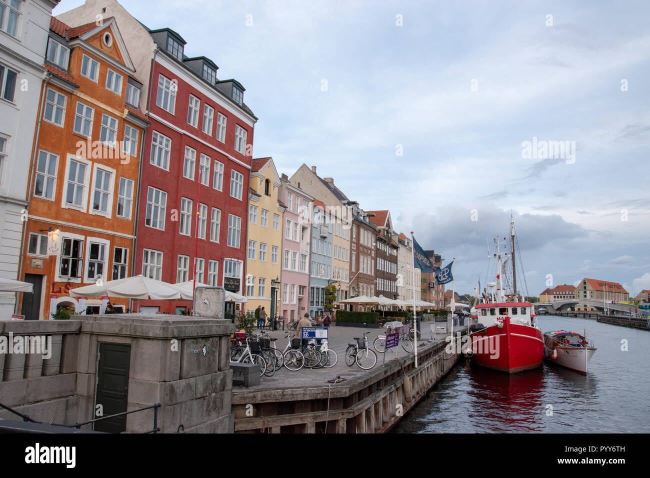 Nyhavn is a 17th centure waterfront, canal and entertainment district in Copenhagen, Denmark. Stretching from Kongens Nytorv to the harbour front and  Stock Photo
