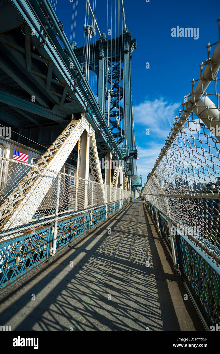 Abstract afternoon view of shadows on the walkway as a subway train passes on the Manhattan Bridge in New York City, USA Stock Photo