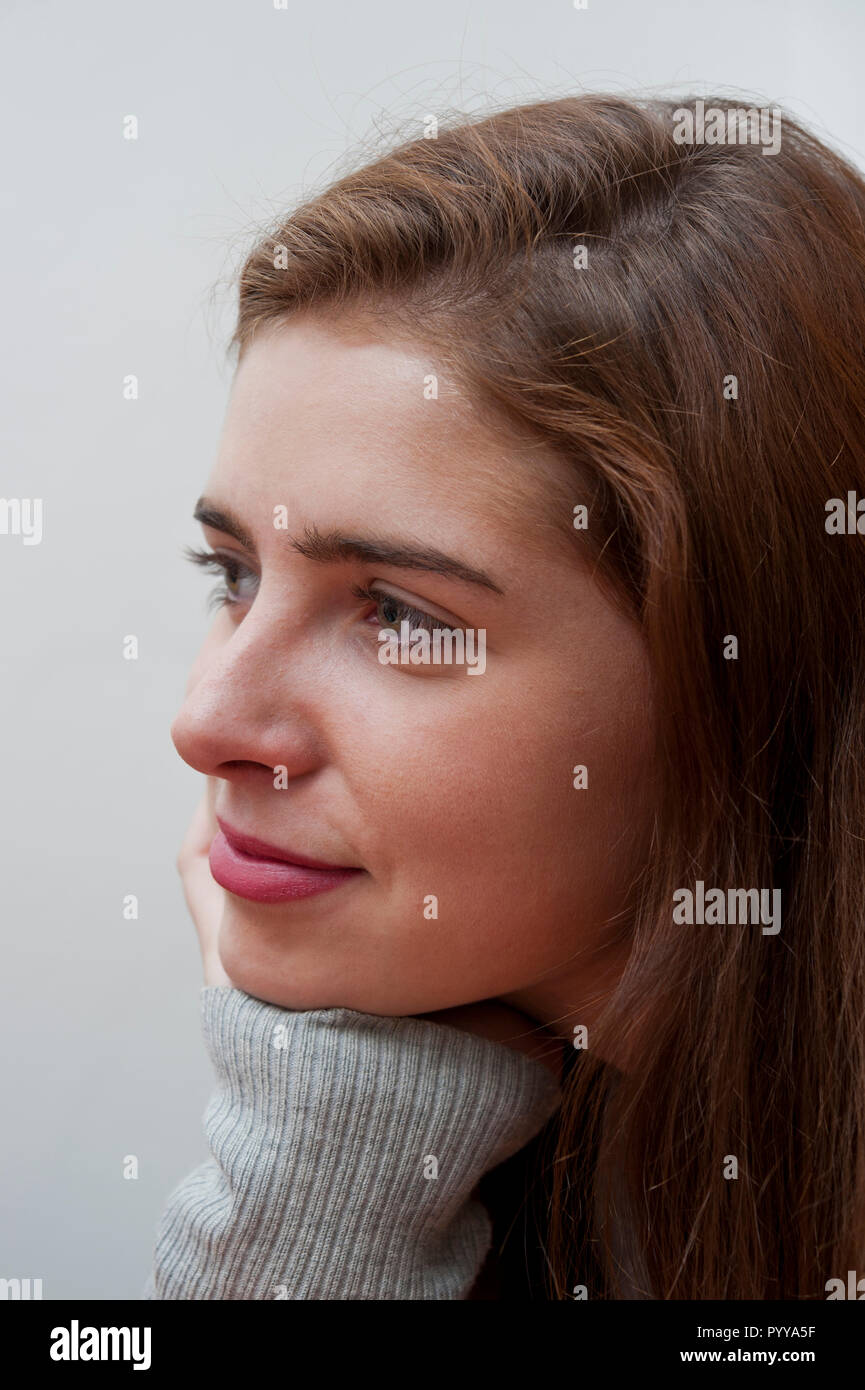 young brunette teenager looking at something and smiling Stock Photo