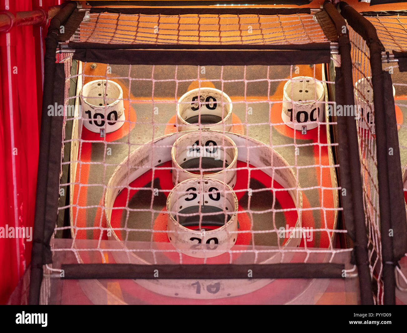 Scoring area of skee ball game behind a net with values of 10 to 100