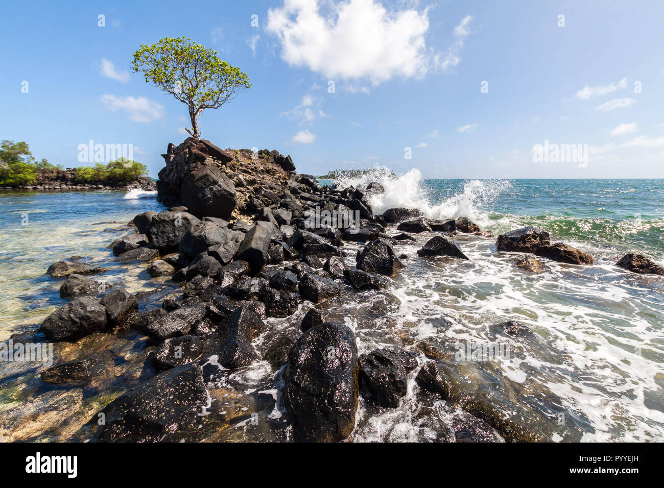 Wave breaks over prehistoric ruined wave breaker made of basalt slabs to shallow lagoon of corals and sand on outskirts of ancient Nan Madol ruined town in Pohnpei, Micronesia, Oceania Stock Photo