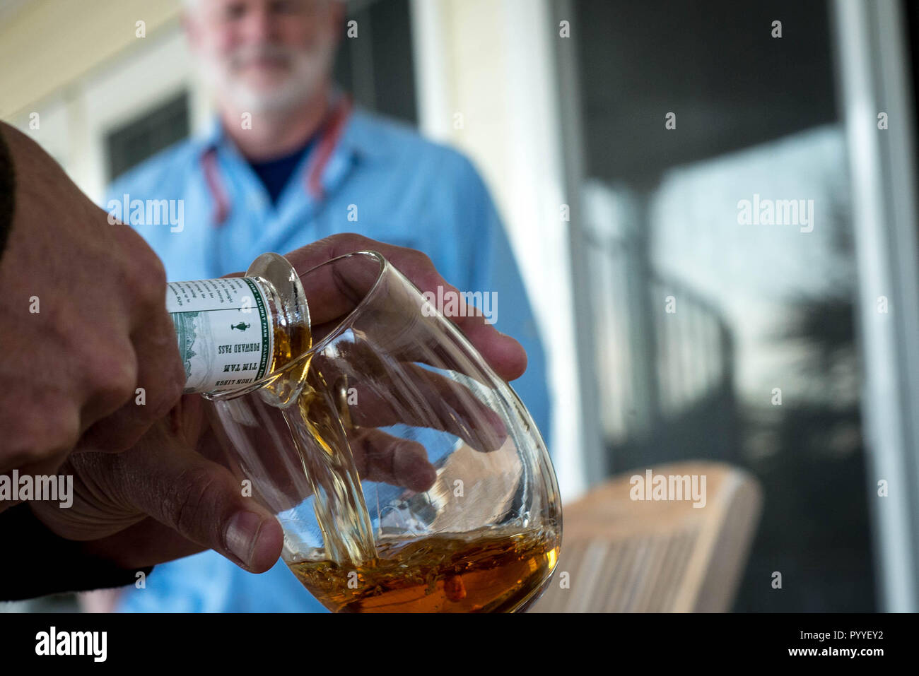 A man shares whisky with friends. Stock Photo