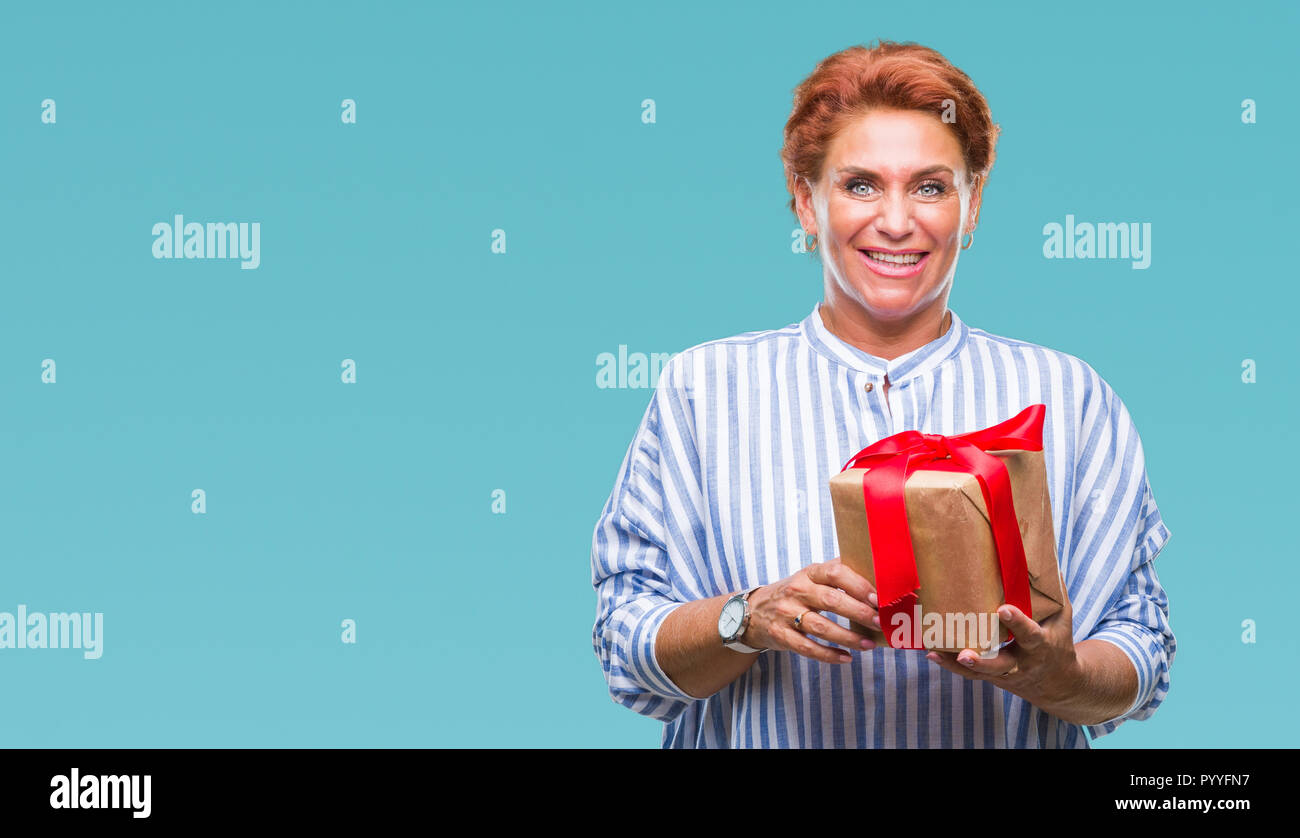 Senior caucasian woman holding gift over isolated background with a ...