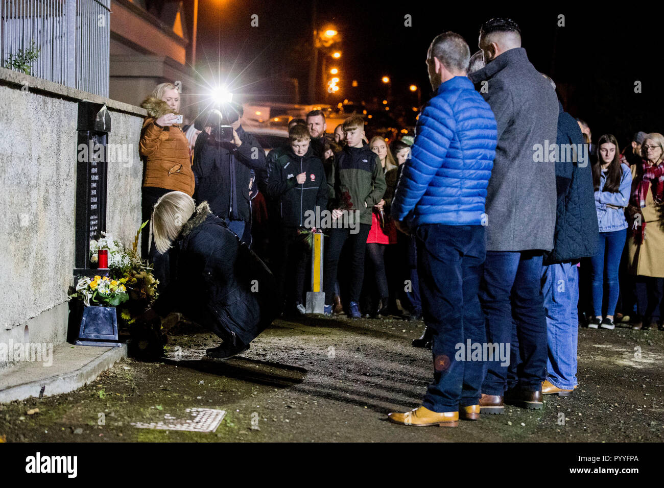 Daughter of John Burns, Gillian laying a wreath, as seven other members of the Greysteel massacre families look on during a vigil to commemorate the 25th anniversary of eight people being murdered on 30 October 1993 by members of the UFF. Stock Photo
