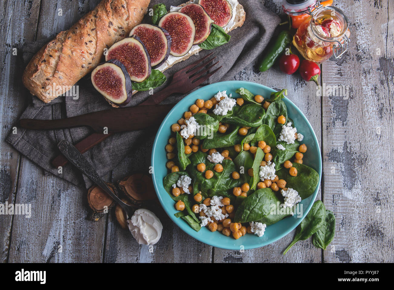 Chickpeas and veggies salad with spinach leaves, homemade cheese,healthy vegan food,sandwich with figs, diet dish Stock Photo