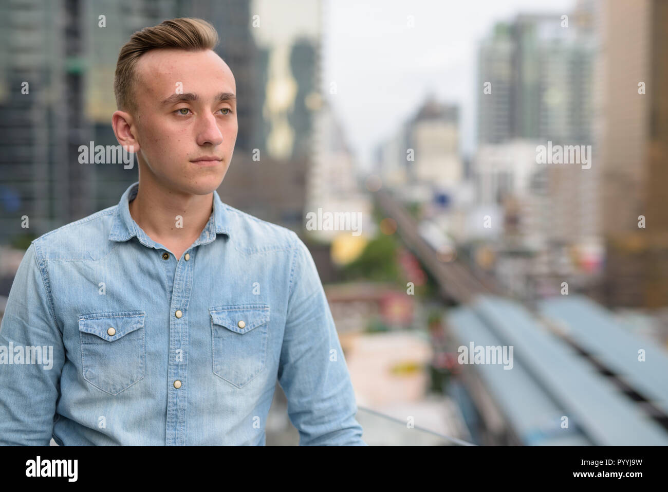 Young Handsome Man With Blond Hair Against View Of The City Stock