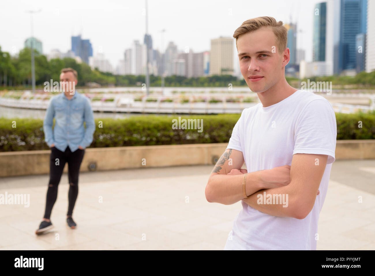 Two Young Handsome Men With Blond Hair Relaxing At The Park Toge