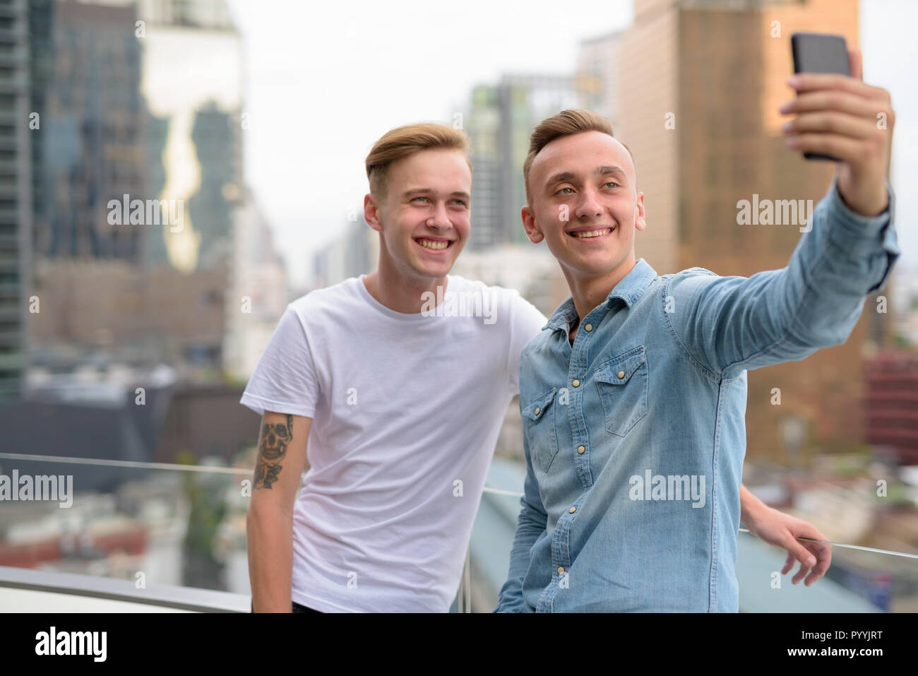 Young happy man couple taking selfie using mobile phone Stock Photo