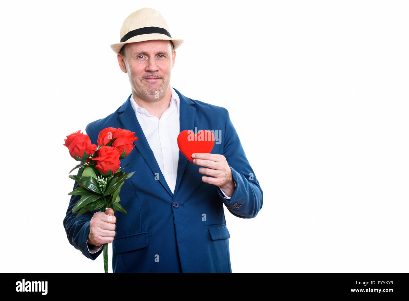 Happy mature businessman smiling while holding red roses and hea Stock Photo