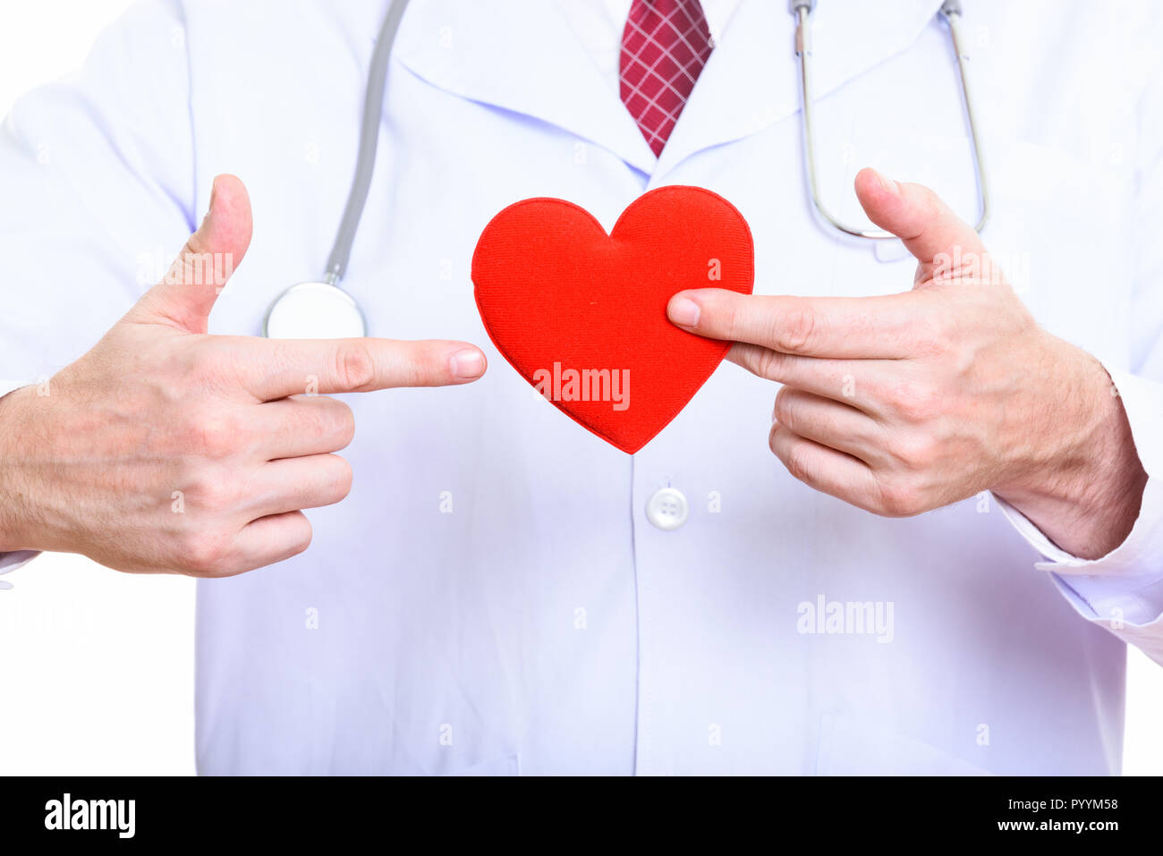 Studio shot of mature man doctor holding red heart and pointing  Stock Photo