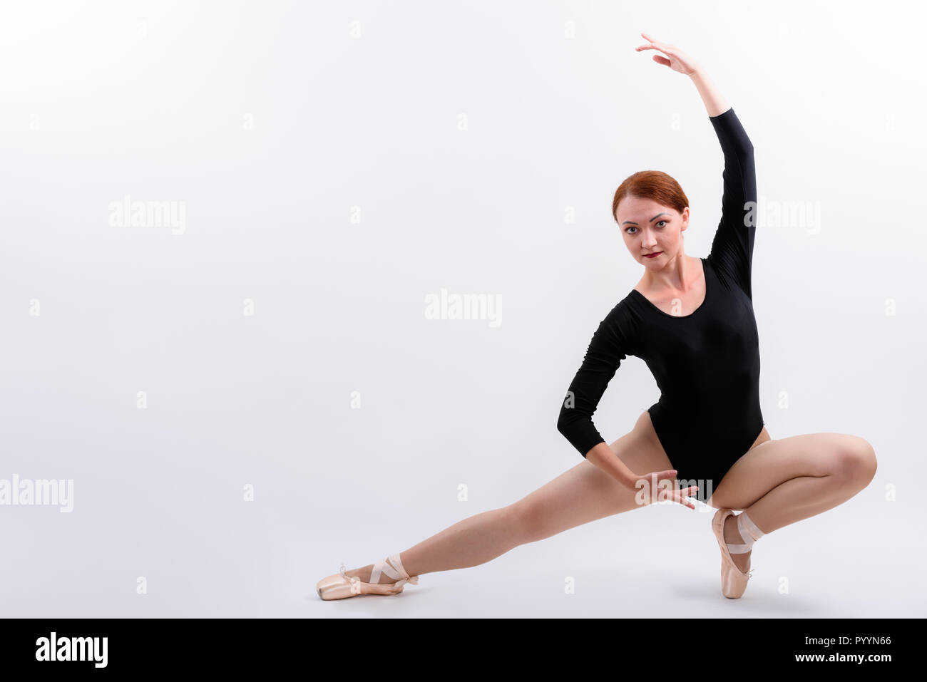 Full body shot of woman ballet dancer posing down on the floor Stock Photo