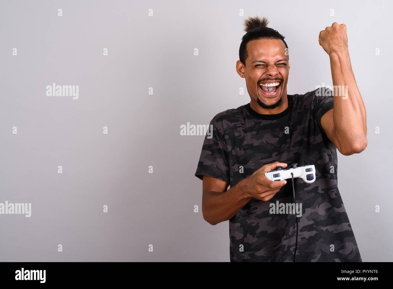 Young bearded handsome African man against gray background Stock Photo