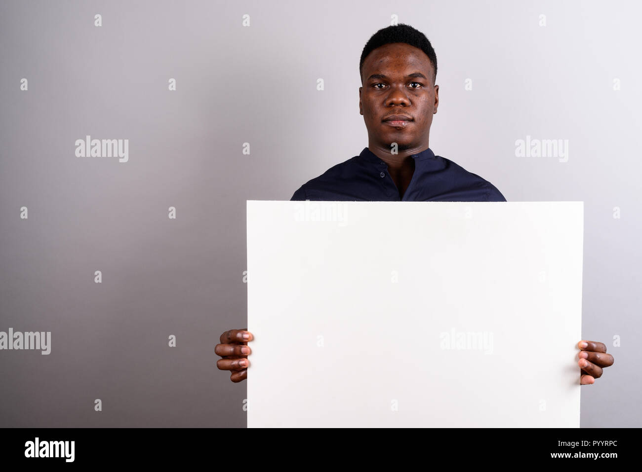 Young African businessman holding white board against white back Stock Photo