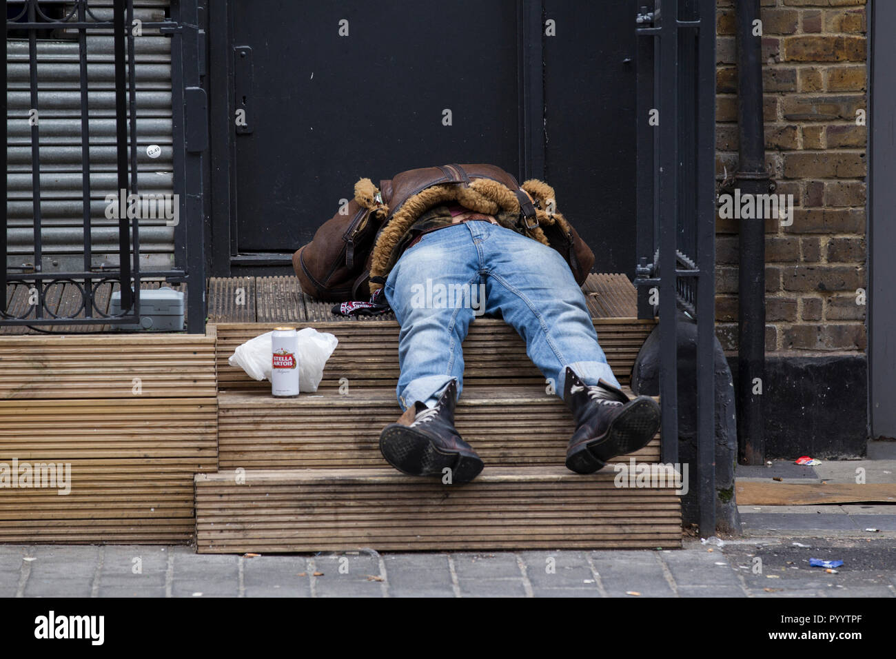 A man who has taken spice drug lies flat out on the pavement steps in