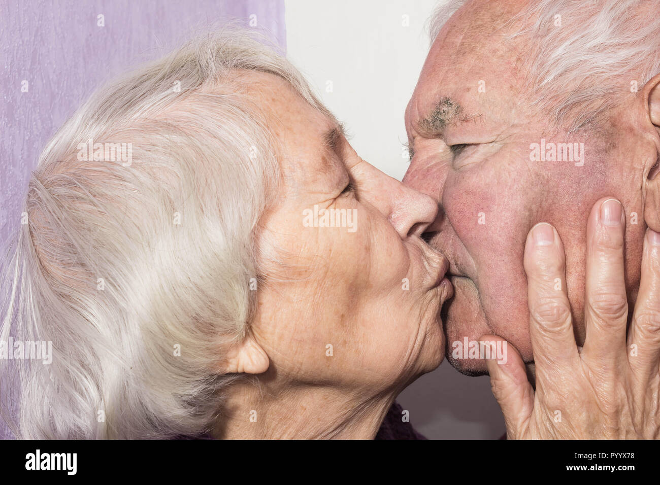 Young man kissing mature woman hi-res stock photography and images