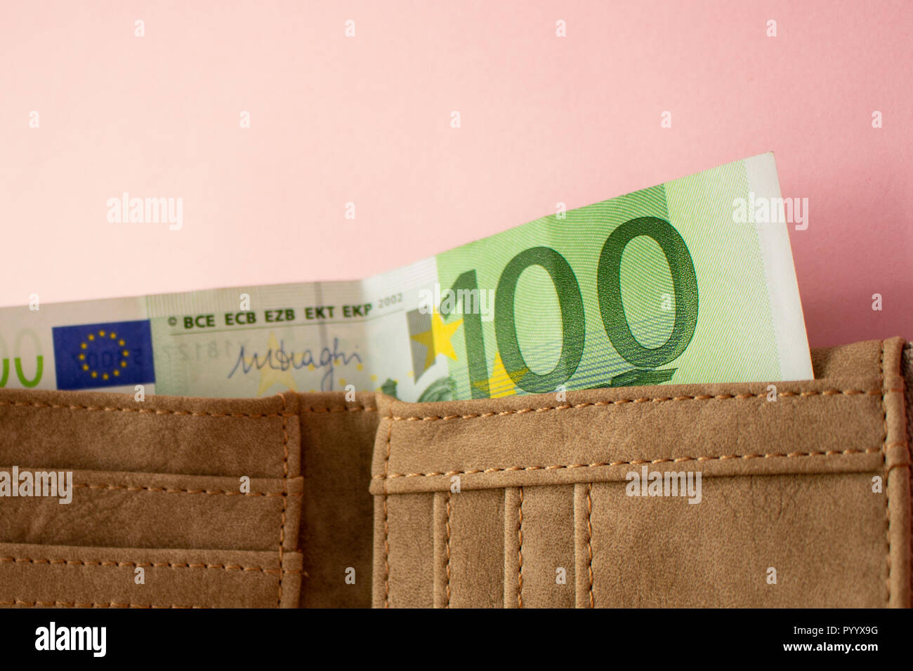 Euro banknote in wallet on pink background Stock Photo - Alamy