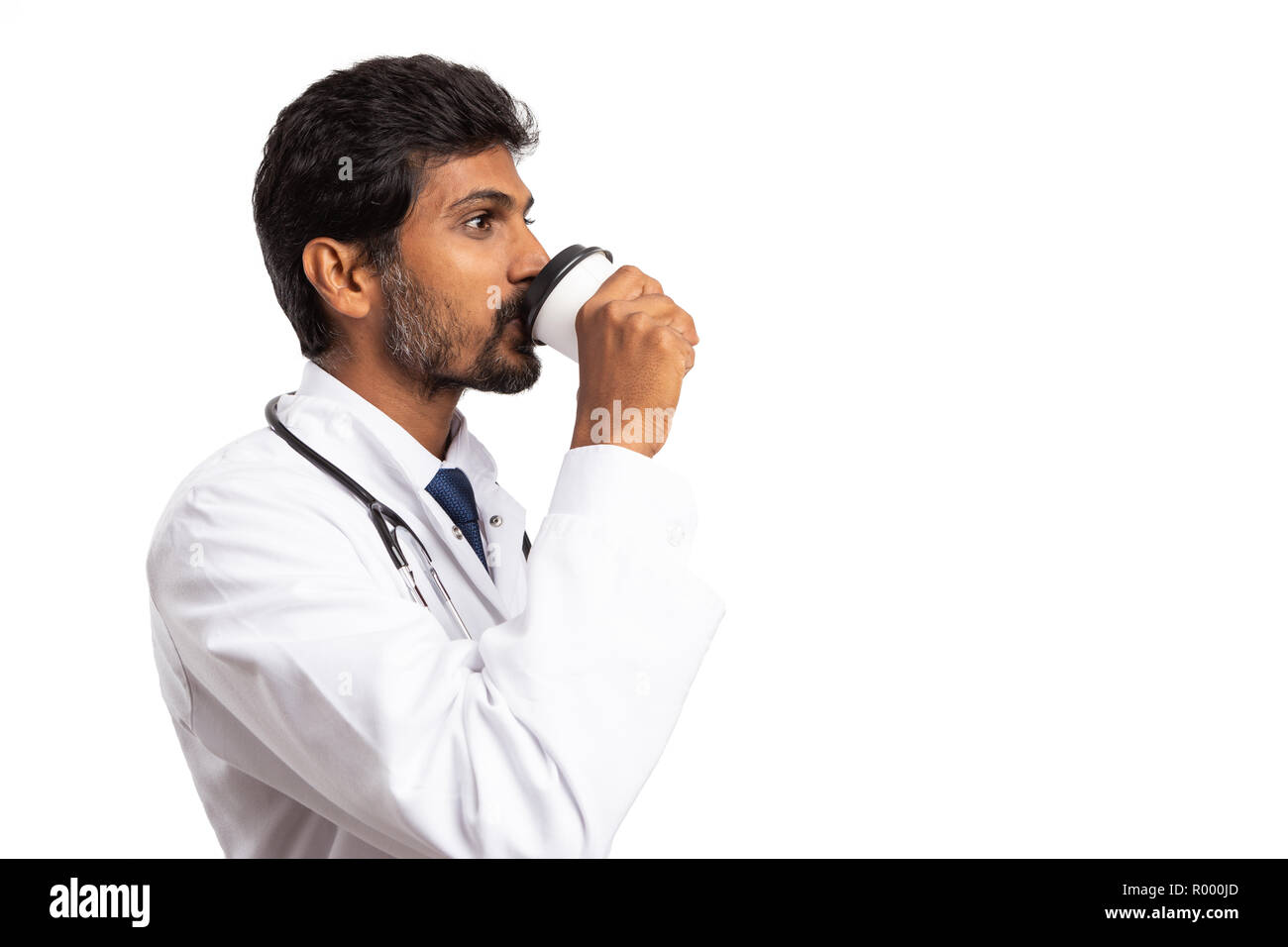 Indian medic drinking coffee during pause as energized concept isolated on white studio background Stock Photo