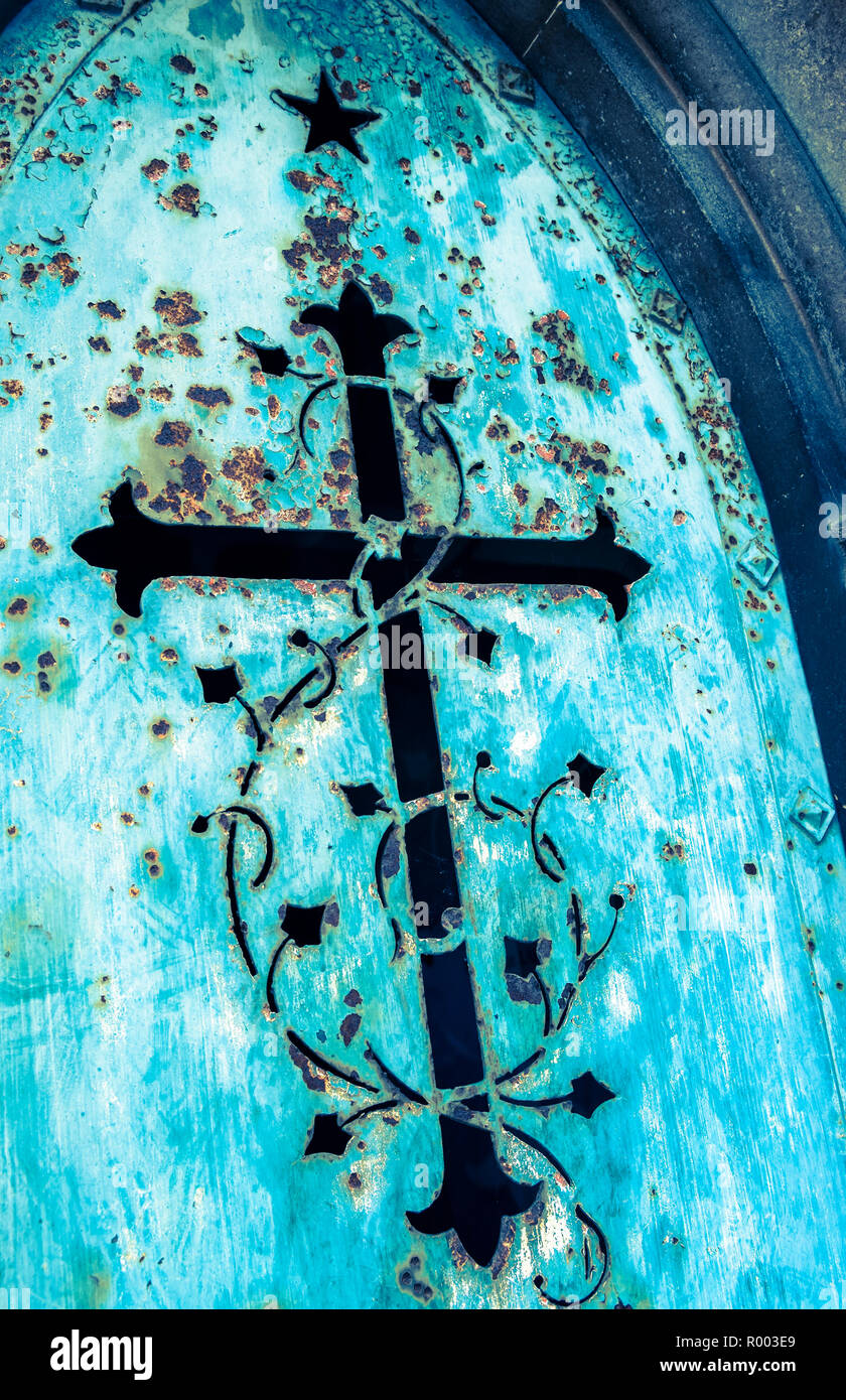 historic metal door showing a cross and floral ornaments Stock Photo