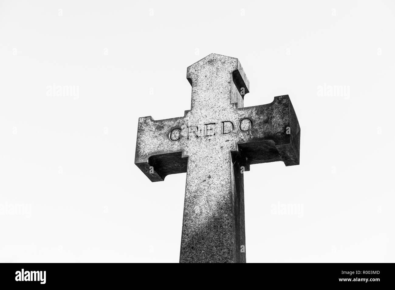 stone cross bearing the word 'credo' against white background Stock Photo
