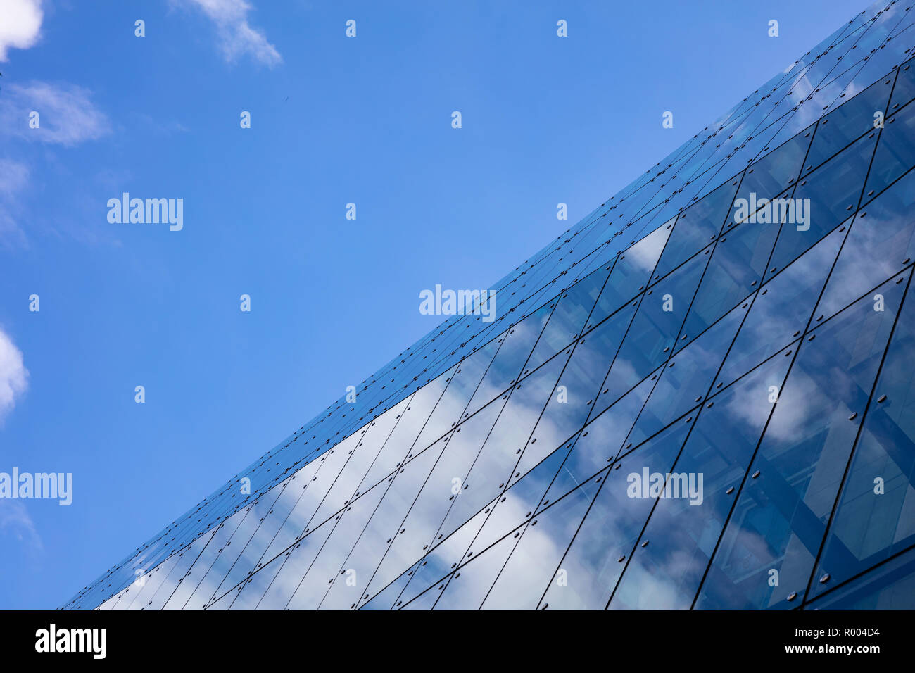 Glass and steel skyscraper multi story office building in Berlin, Germany, low angle, against blue sky background. Stock Photo