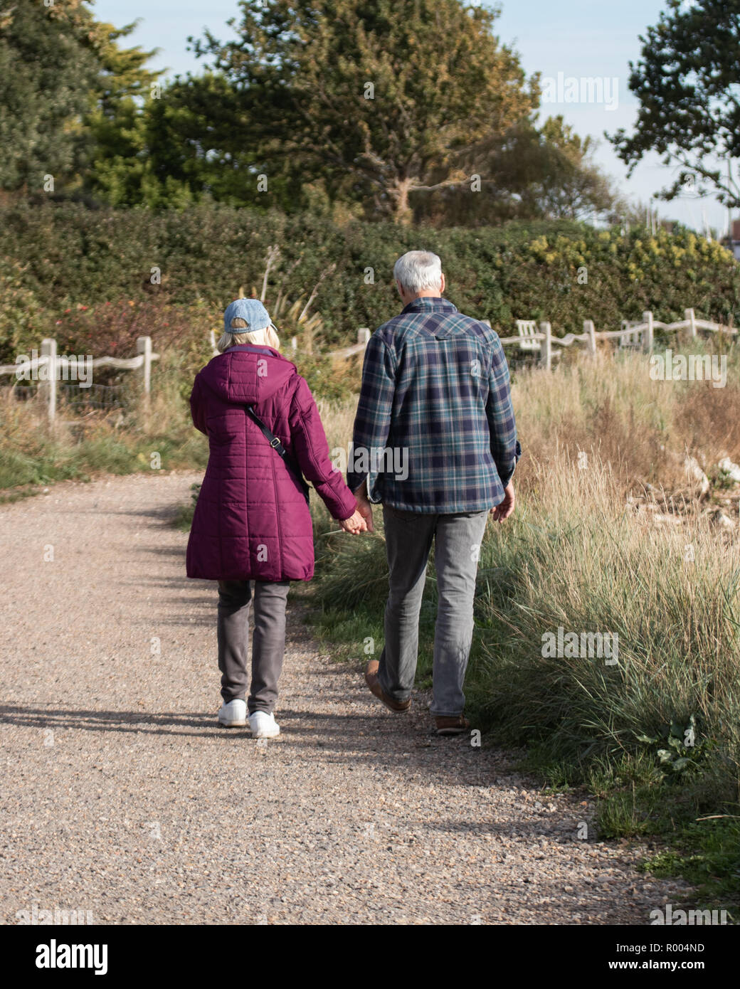 An elderly couple walking on path holding hands Stock Photo