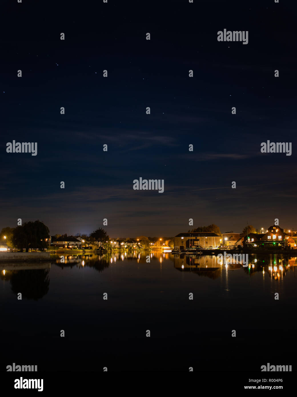 houses at Emsworth Mill pond reflecting on the water at night Stock