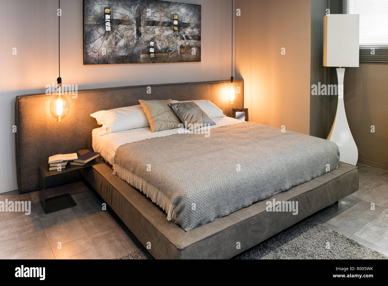 View Of Double Bed With Grey Linens In Cozy Interior With Warm