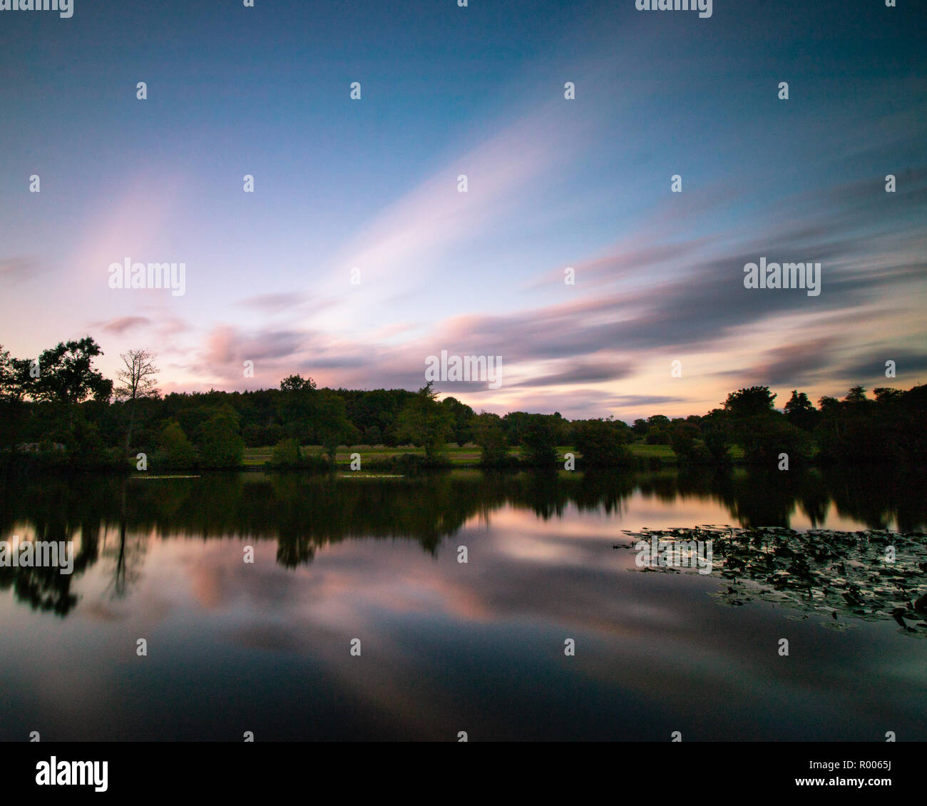 sunset reflections on a calm lake Stock Photo