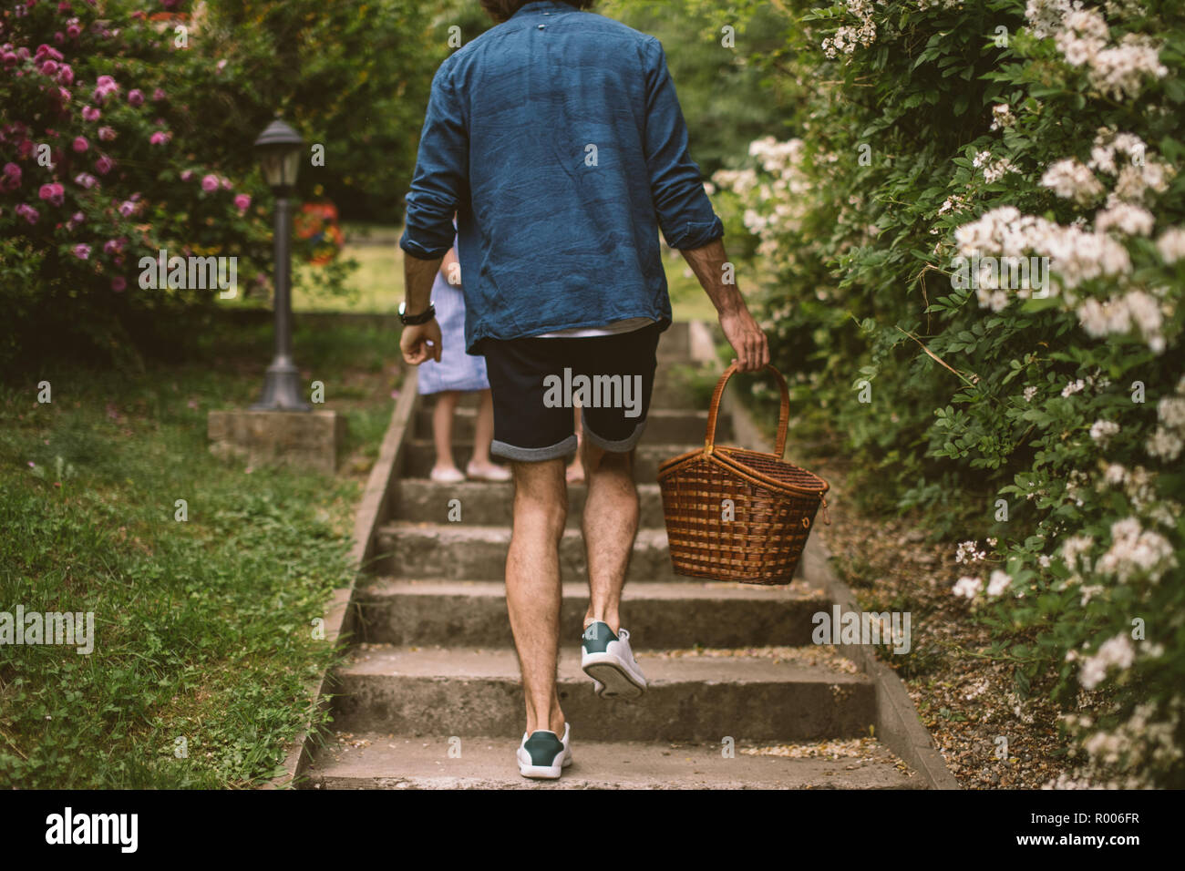 rear view of man with family walk on picnic, stairs with basket Stock Photo