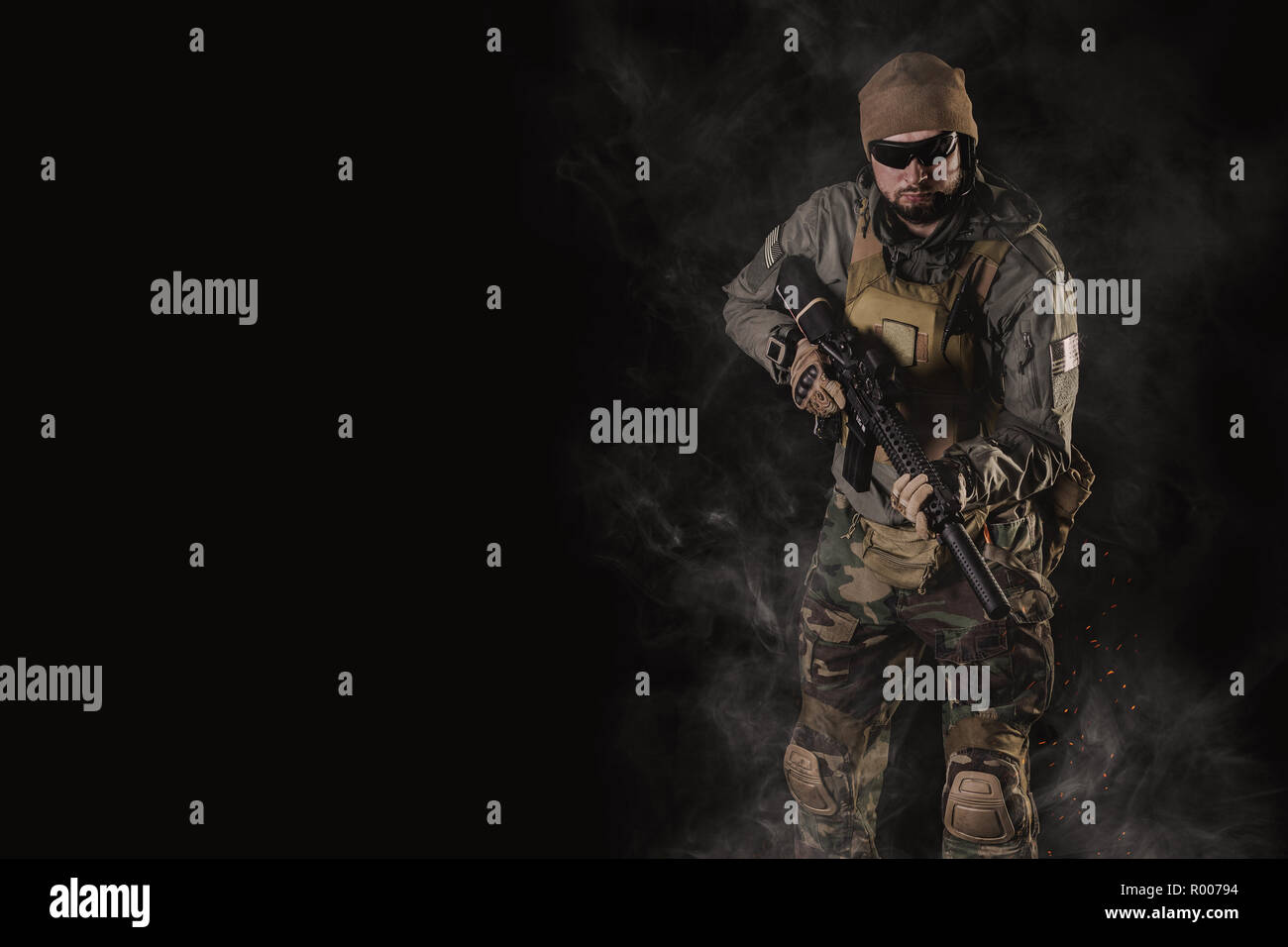 Special Forces soldier with an assault rifle on a black background ...
