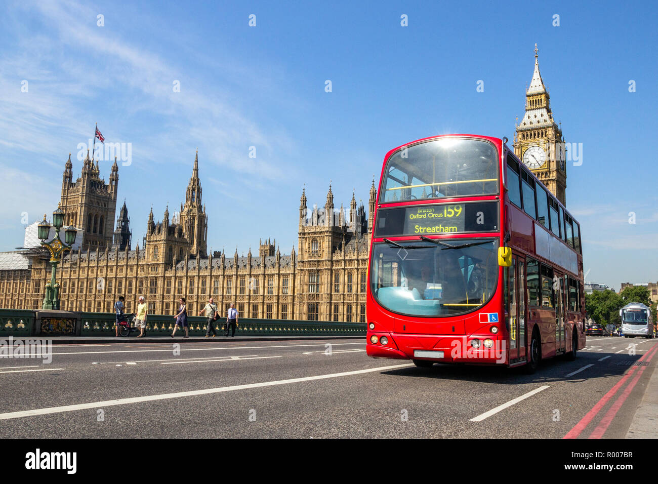 Double decker bus driving on the Westminster Bridge bridge with the Big Ben tower clock in the background. London, UK Stock Photo