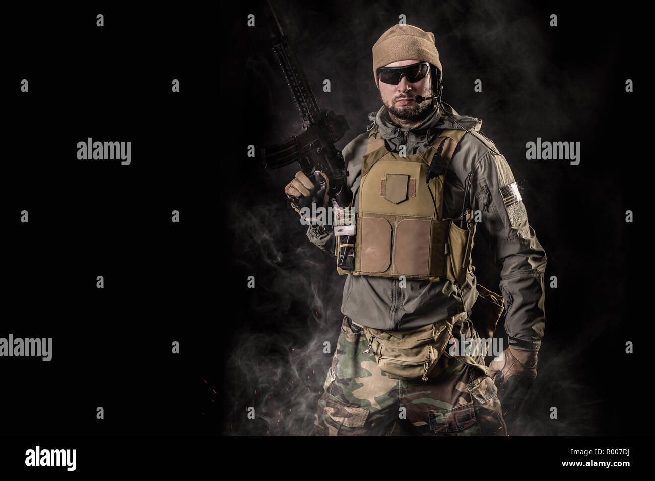 Special Forces soldier with an assault rifle on a black background ...