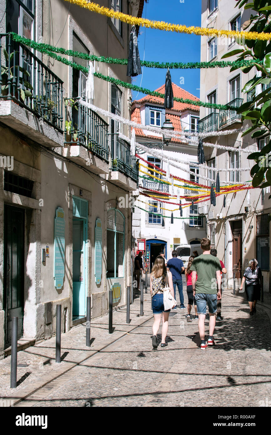 Tourist in the decorated narrow streets of the Alfama district, Lisbon ...