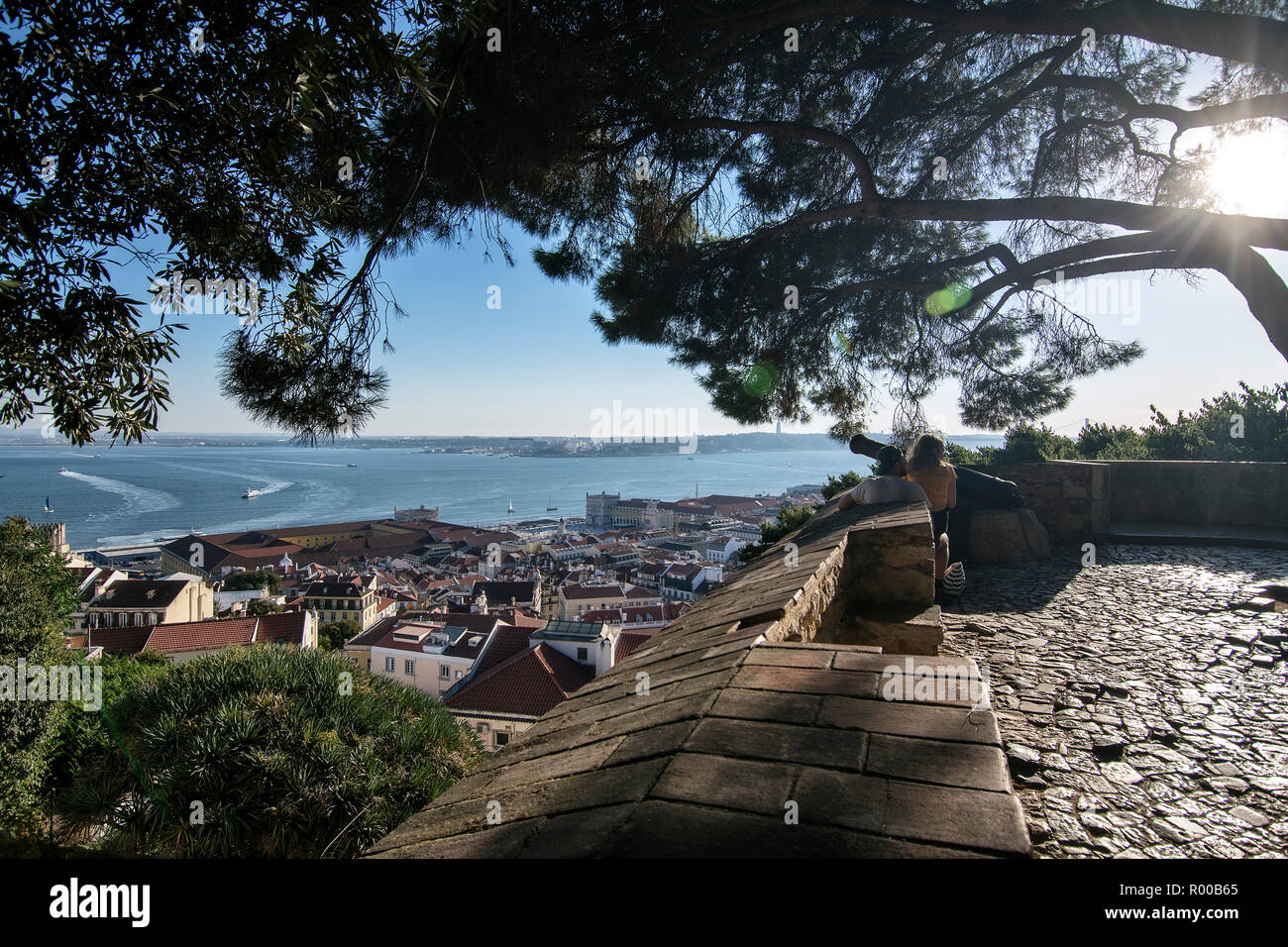 Tourists at the Miradouro do Castelo de Sao Jorge view point in the Alfama district with a view of the city and the Tagus River, Lisbon, Portugal. Stock Photo